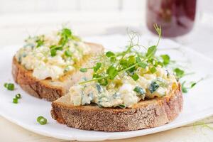 délicieux pain grillé avec crâne bouilli œuf, concombre et crème fromage sur une blanc plaque. en bonne santé alimentaire, petit déjeuner. céto régime aliments. savoureux aliments. photo