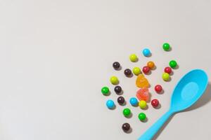 cœur en forme de bonbons et multi coloré marbre bonbons avec cuillère sur isolé sur blanc Contexte. photo