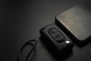 porte-clés de voiture et smartphone se trouvent sur un panneau noir photo