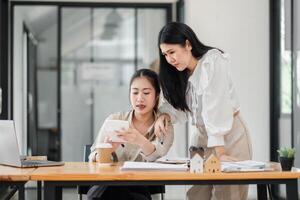 concentré femme d'affaires discuter travail sur une numérique tablette dans une moderne bureau, avec formalités administratives et une portable sur le bureau. photo