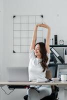 femme d'affaires prend une moment à étendue et se détendre à sa bureau, dans une brillant et aéré Bureau espace. photo