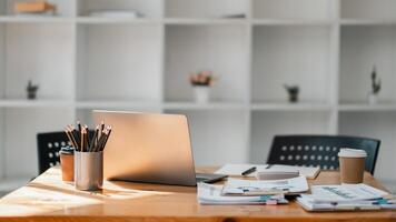 minimaliste Bureau bureau installer avec une lisse ordinateur portable, une tasse de café, et soigneusement arrangé travail les documents dans une brillant espace. photo