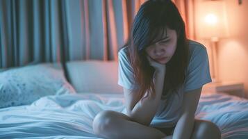 asiatique fille sentiment triste et solitaire dans le chambre en dessous de faible lumière photo