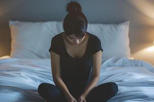 asiatique fille sentiment triste et solitaire dans le chambre en dessous de faible lumière photo