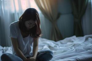 asiatique fille sentiment triste et solitaire dans le chambre en dessous de faible lumière photo