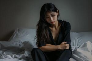 asiatique fille sentiment triste et solitaire dans le chambre en dessous de faible lumière photo