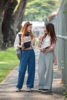 Université étudiant fille copains avec apprentissage livre Université tandis que en marchant dans Campus photo