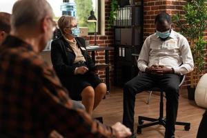 psychiatre parlant à un homme afro-américain lors d'une séance de thérapie de groupe