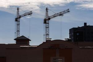 silhoette de la tour grues sur construction placer, fournir logement pour faible revenu citoyens de troisième monde des pays photo