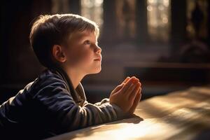 peu garçon en train de lire prière dans église photo