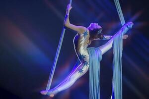 performance par une cirque acrobate artiste. les filles effectuer aérien acrobatique éléments sur tissu. photo