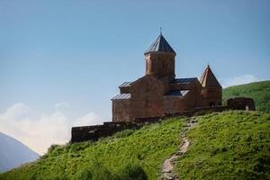 proche vue de saint trinité église dans Kazbegi Montagne intervalle près stepantsminda vue Caucase montagnes dans le Contexte photo