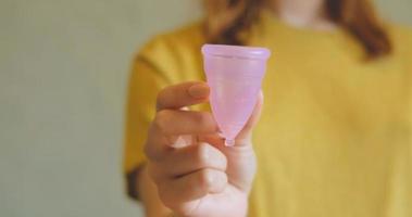 gros plan de la coupe menstruelle dans les mains de la femme. concept zéro déchet et respectueux de l'environnement photo