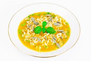 soupe de citrouille avec nouilles, légumes verts et graines de citrouille photo