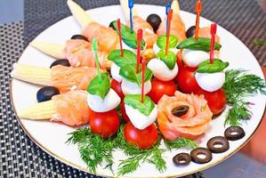 assiette assortie. saumon au maïs, tomates à la mozzarella. photo