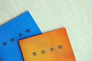 Japonais Pension Assurance livrets sur tableau. bleu et Orange Pension livre pour Japon photo