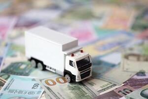 livraison un camion sur beaucoup billets de banque de différent monnaie. Contexte de camionnage ou en mouvement concept photo