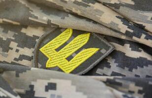 symbole de ukrainien armée sur le camouflage uniforme de une ukrainien soldat. le concept de guerre dans Ukraine, patriotisme et protéger votre pays de occupants photo