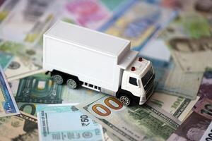 livraison un camion sur beaucoup billets de banque de différent monnaie. Contexte de camionnage ou en mouvement concept photo