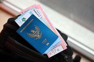 bleu république Indonésie passeport avec argent et Compagnie aérienne des billets sur touristique sac à dos photo