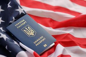 ukrainien biométrique passeport sur plié agitant drapeau de uni États de Amérique photo