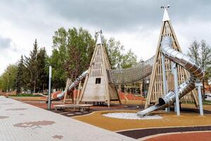 amusement parc, enfants terrain de jeux sur le rue dans le ville, des loisirs parc avec le entier famille, en marchant avec enfants, faire glisser tuyau, escalade arbre, mégaparc photo