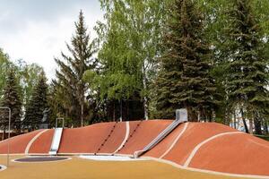 métal diapositives sur le Cour de récréation, une moderne ville des loisirs parc pour le famille, un Orange Montagne fabriqué de caoutchouc, une protecteur enrobage contre blessure. photo