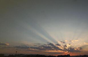 magnifique lever du soleil avec chaud Orange lumière du soleil et poutres par bleu ciel photo