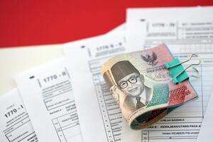 indonésien impôt formes 1770 individuel le revenu impôt revenir et argent sur table photo