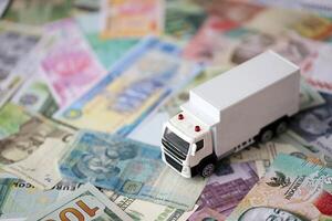 livraison un camion sur beaucoup billets de banque de différent monnaie. Contexte de camionnage ou en mouvement concept photo