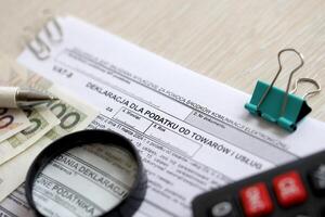 déclaration pour impôt sur des biens et prestations de service cuve-8 forme sur comptable table avec stylo et polonais zloty argent factures photo