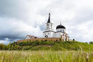 orthodoxe monastère pour croyants, église dans Russie ville de bouleau Bachkortostan. le temple contre le Contexte de le ciel, le forteresse structure est une haute fossé. photo