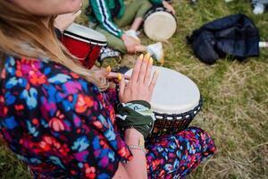 le fille tambours sur le djemba Festival de la musique dans nature, rue les musiciens, jouer le percussion instrument percussion. photo