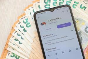 ternopil, Ukraine - août 3, 2023 capitec application sur écran sur moderne téléphone intelligent et beaucoup factures de euro devise photo