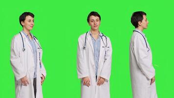 portrait de médecin portant une blanc manteau et une stéthoscope pour examens, permanent contre écran vert toile de fond. médecin spécialiste travail dans soins de santé industrie, médical compétence. caméra b. photo
