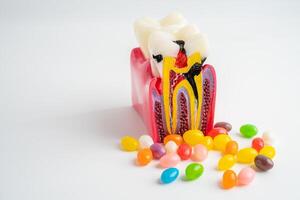 dent pourriture modèle avec coloré bonbons sucré nourriture sur blanc Contexte avec copie espace. photo