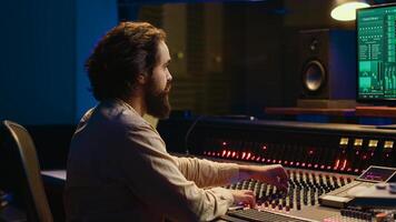 contrôle pièce du son ingénieur édition la musique avec curseurs et boutons, travail sur Publier production dans professionnel insonoriser studio. technicien produisant Chansons sur stéréo mélange console. caméra un. photo