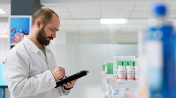 médical ouvrier compte médicaments des boites mis sur étagères, travail sur pharmacie inventaire à assurer plein Stock pour clients. pharmacien Faire logistique activité avec paquets de pilules. photo