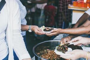 distribuer nourriture à Aidez-moi le pauvres dans société partage nourriture à le faim nourriture don concept photo