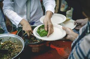 le mains de mendiants recevoir donné aliments. concept de charité nourriture pour le pauvres photo