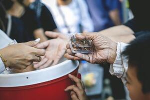 bénévoles Aidez-moi distribuer gratuit nourriture à le affamé. photo