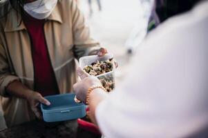 alimentation le pauvres à mains de une mendiant. la pauvreté concept photo