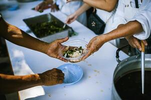 concept de charité nourriture pour le pauvres . le concept de la vie problèmes, faim dans société . portion gens avec faim avec gentillesse. le mains de mendiants recevoir donné nourriture photo