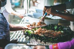 sans abri gens atteindre en dehors à recevoir gratuit nourriture cette bénévoles apporter. à Aidez-moi soulager faim photo