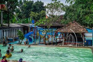 Jepara, central Java, avril 14, 2024 - nager bassin monte entouré par des arbres sont plein de visiteurs pendant vacances. photo