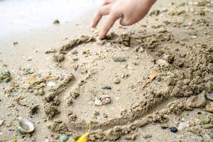 dessiner une signe de l'amour sur le le sable de le littoral. photo