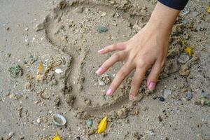 dessiner une signe de l'amour sur le le sable de le littoral. photo