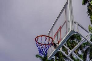 fermer vue de une basketball panier contre une nuageux ciel Contexte. photo