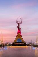 Ouzbékistan, Tachkent - septembre 15, 2023 monument de indépendance dans le forme de une stèle avec une humo oiseau sur une crépuscule avec spectaculaire cloïdes dans le Nouveau Ouzbékistan parc. photo