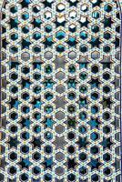 le fenêtre de une musulman mosquée derrière bars dans le forme de une géométrique hexagonal islamique ornement. photo